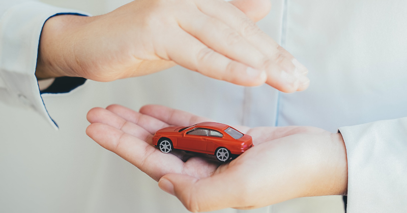 Petite voiture protégée pour symboliser l'assurance auto