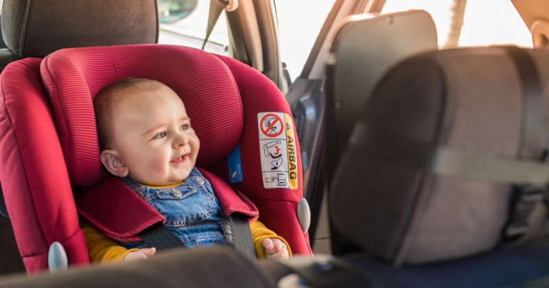 Bébé installé dans son siège auto, en voiture