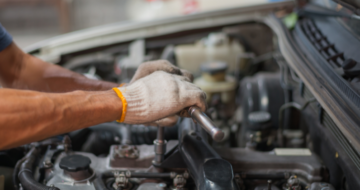 Mains de mécanicien travaillant sur un moteur de voiture