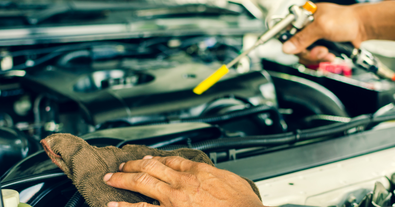 Mains de mécanicien intervenant sur un moteur de voiture