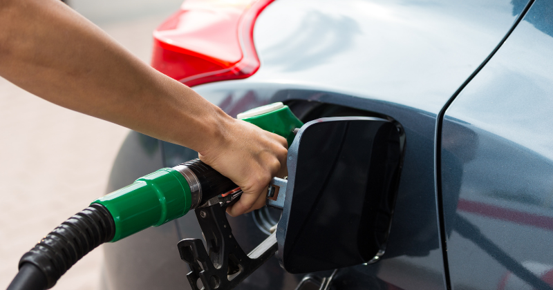 Gros plan sur la main d'un conducteur en train de faire le plein de carburant