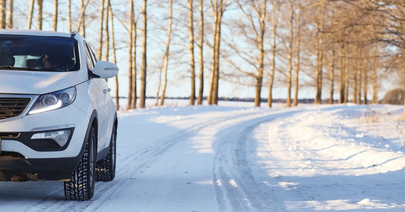 Voiture roulant sur une route enneigée