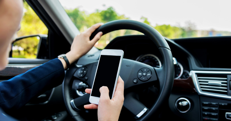 Gros plan d'un conducteur utilisant son téléphone