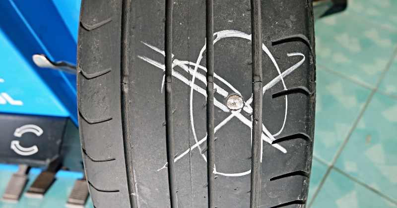 zoom sur un pneu percé d'une pointe