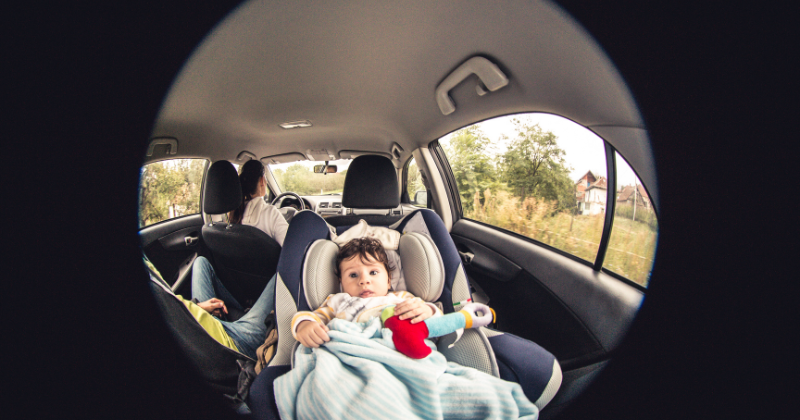 Bébé dans son siège auto vu à travers le miroir de sécurité : accessoire voiture bébé utile