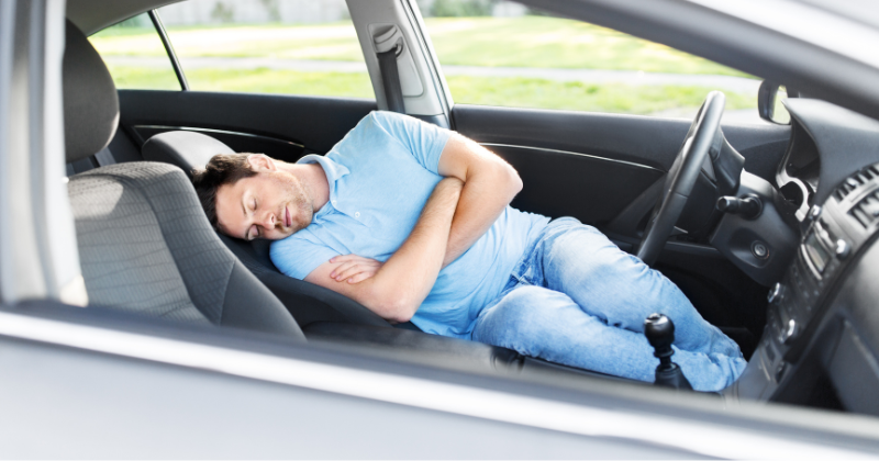 Homme faisant la sieste dans sa voiture