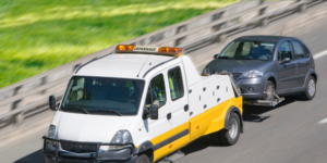 Crevaison sur autoroute, voiture remorquée par le camion de dépannage