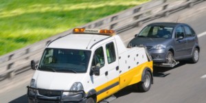 Crevaison sur autoroute, voiture remorquée par le camion de dépannage